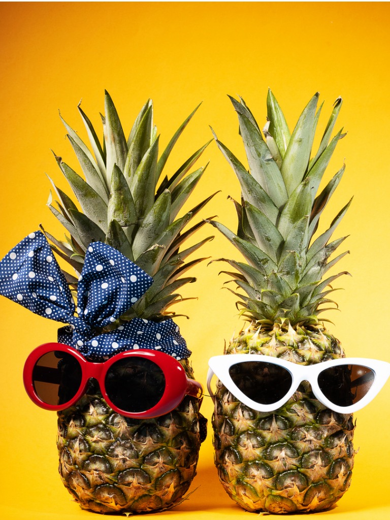 two pineapples wearing sunglasses